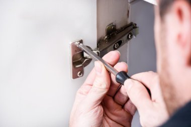 Adam bir kabine bir tornavida ile sabitleme