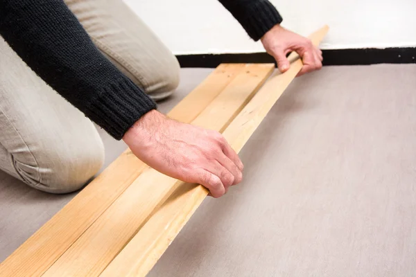 Man putting wood floor — Stock Photo, Image