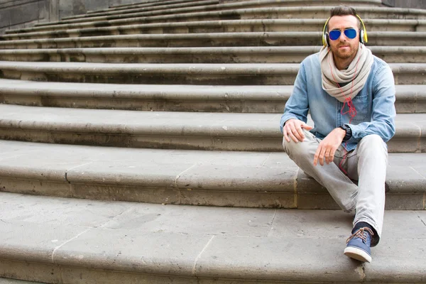 Young man sitting on a stairs — Stock Photo, Image