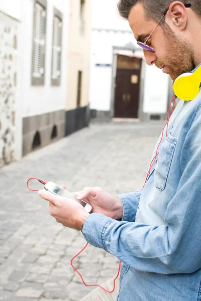 Mann hört Musik mit Handy auf der Straße — Stockfoto