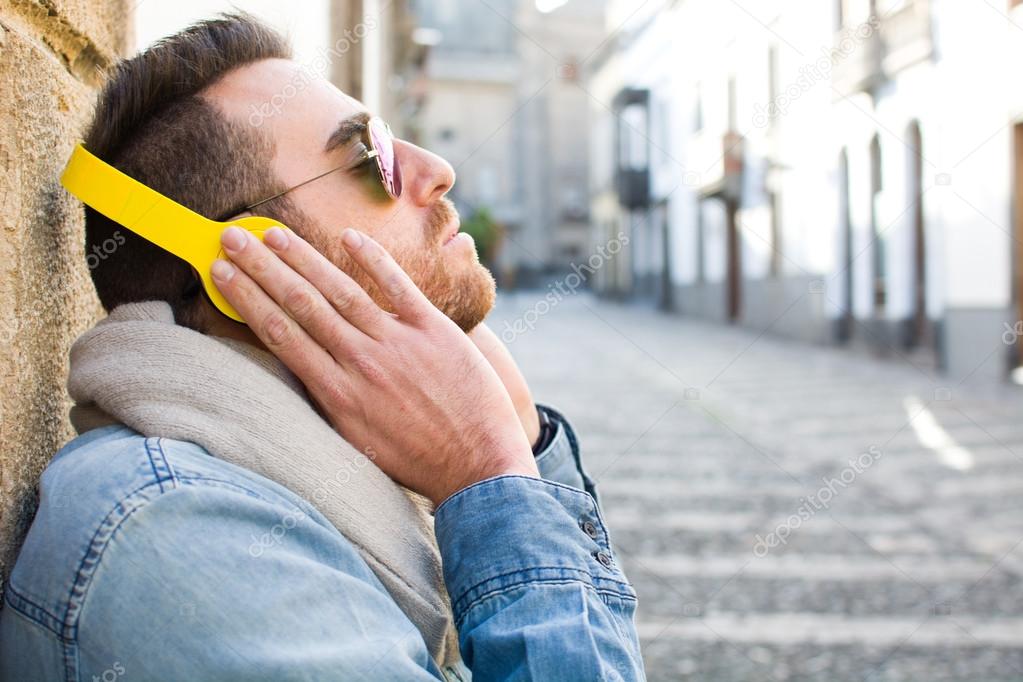 Man listening to music with mobile phone in the street