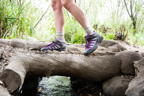 Woman hiking on top of a stream — Stock Photo, Image
