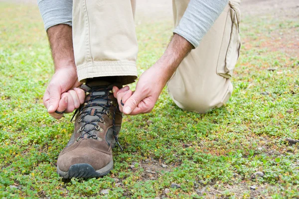 Hombre senderismo haciendo el nudo zapatos — Foto de Stock