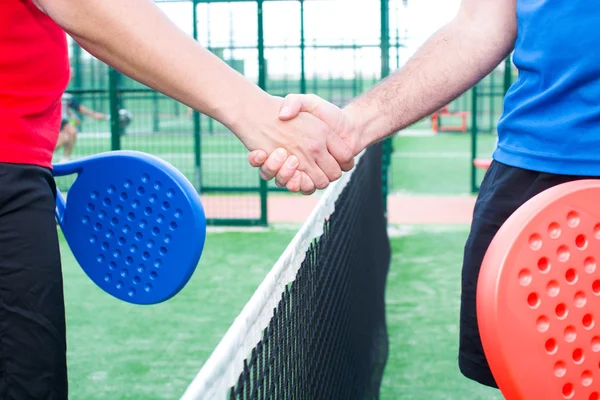 Vänner skakar hand i paddel tennis — Stockfoto