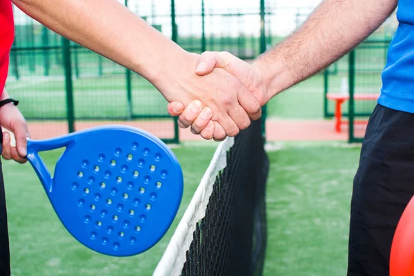 Vänner skakar hand i paddel tennis — Stockfoto