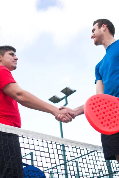 Друзья пожимают руки в весло-теннисе — стоковое фото