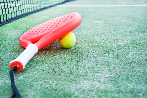 Paddel tennisracket och boll i paddel tennis fält Stockbild