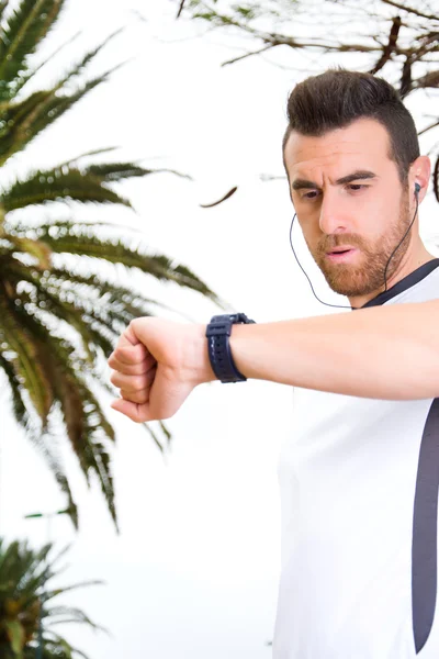 Man doing running and watching the watch in park — Stock Photo, Image