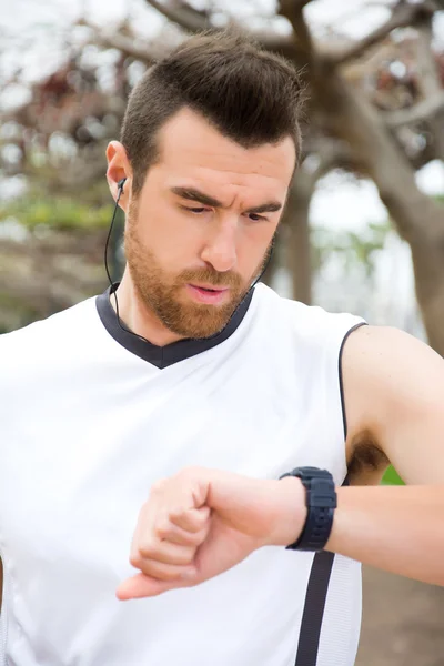 Man doing running and watching the watch in park — Stock Photo, Image