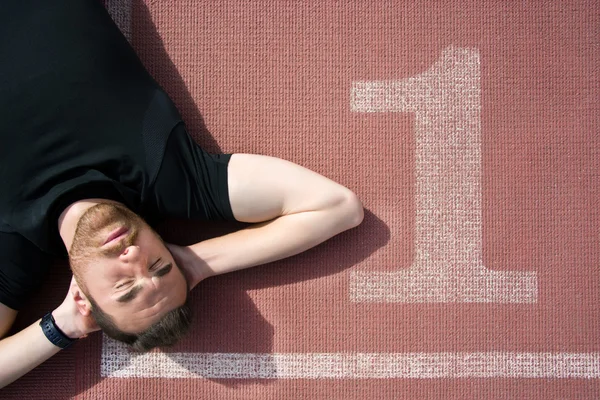 Man lying on the running track — Stock Photo, Image