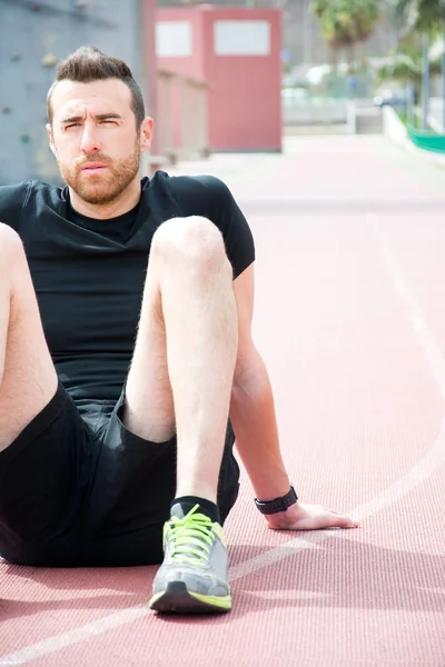 Man sitting on the running track — Stock Photo, Image