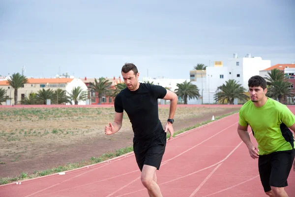 Two men running on running track — Stock Photo, Image