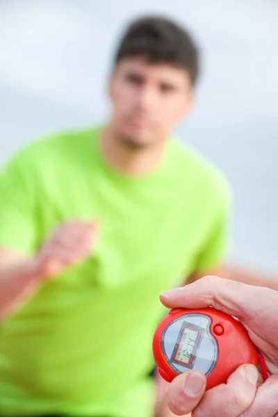 Runner and timer in running track — Stock Photo, Image