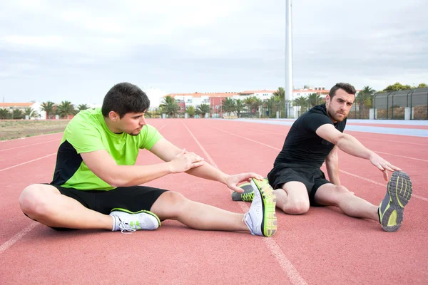 Men stretching in running track