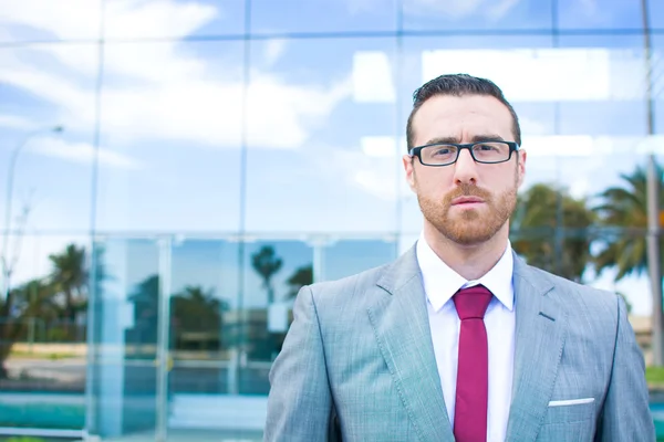 Businessman with glasses  offices behind — Stock Photo, Image