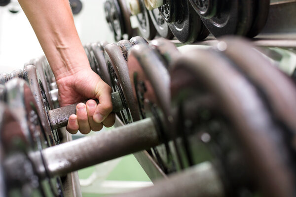 Man picking up dumbbells in a gym