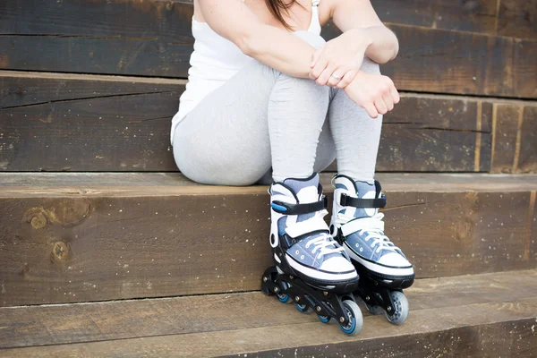 Junge Frau mit Rollschuhen auf einer Treppe sitzend — Stockfoto