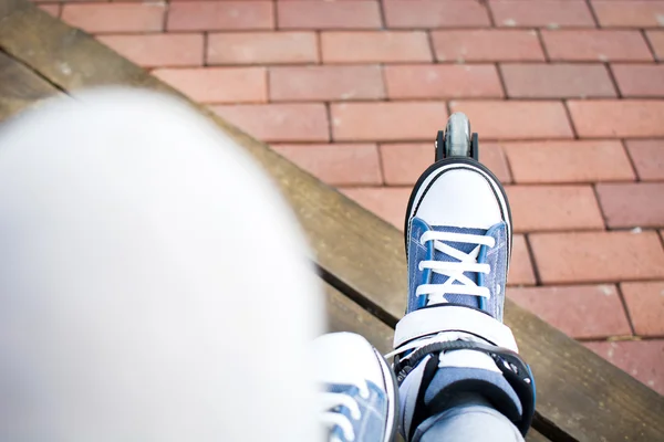 Mladá žena s roller-skates sedí na schodiště — Stock fotografie