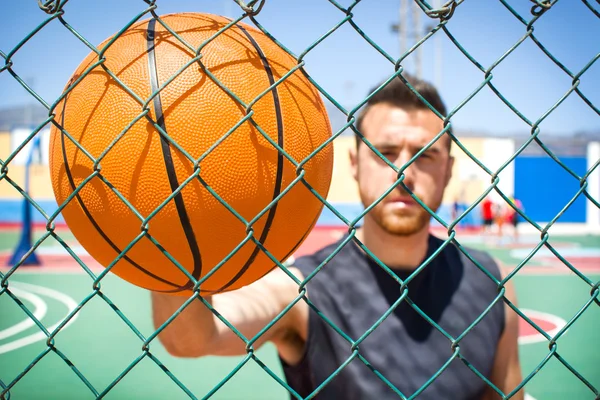 Bir çitin arkasında bir basketbol ile genç adam — Stok fotoğraf