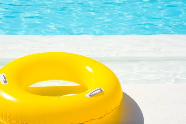 Flotador amarillo de la piscina en la piscina azul — Foto de Stock