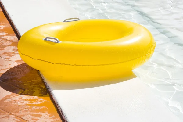 Flotador amarillo de la piscina en la piscina azul — Foto de Stock