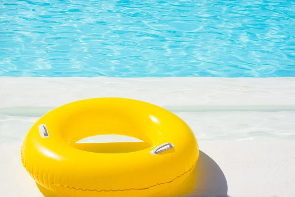 Flotador amarillo de la piscina en la piscina azul — Foto de Stock