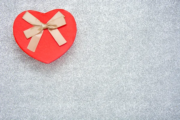 Caja de regalo con forma de corazón sobre fondo plateado —  Fotos de Stock