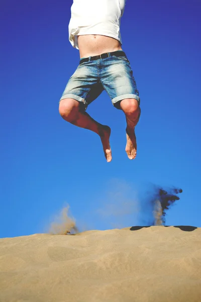 Young man jumping on a dune — Stock Photo, Image