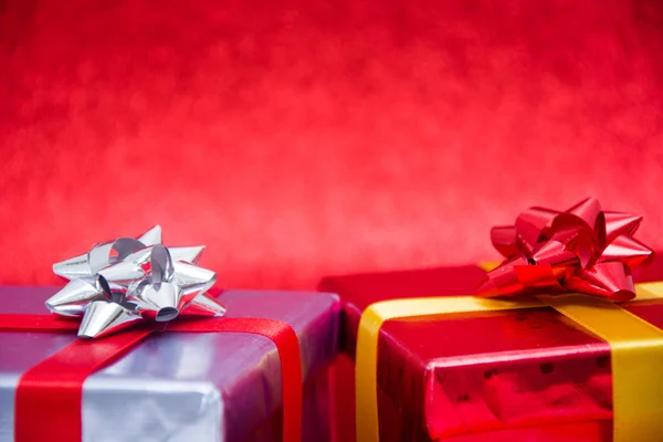Барвисті подарункові коробки на червоному тлі — стокове фото