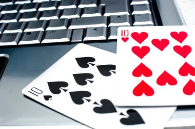 Dizüstü bilgisayar, poker kartları ve poker fişleri