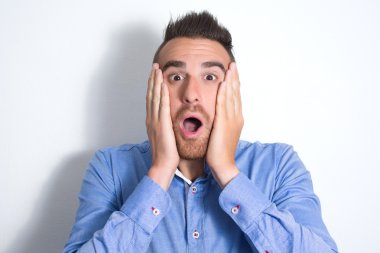 Sürpriz bir bakışla genç adam. Duvarda gölge.