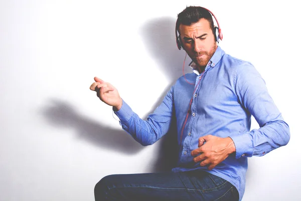 Man listening music with headphones and playing air guitar — Stock Photo, Image