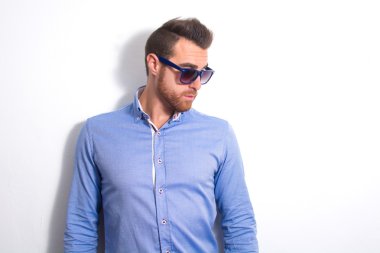 Genç adam bir model olarak poz. Duvarda gölge