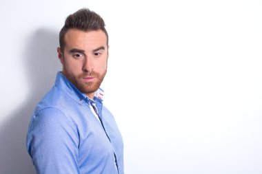 Genç adam bir model olarak poz. Duvarda gölge