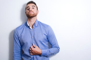 Genç adam bir model olarak poz. Duvarda gölge