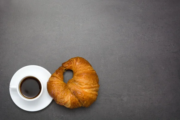 コーヒーと黒の背景のクロワッサン — ストック写真
