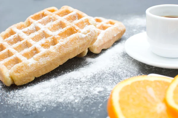 Waffeln, Kaffee und Orangen auf dem Schiefertisch in der Küche — Stockfoto