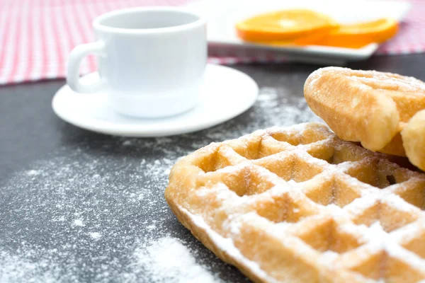 Waffeln, Kaffee und Orangen auf dem Schiefertisch in der Küche — Stockfoto