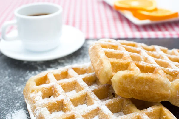 Gofres, café y naranjas en la mesa de pizarra en la cocina —  Fotos de Stock