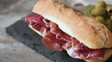 Tahta masada İspanyol jambonlu sandviç. İspanyol Bocadillo de jamon Serrano