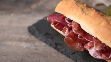 Tahta masada İspanyol jambonlu sandviç. İspanyol Bocadillo de jamon Serrano