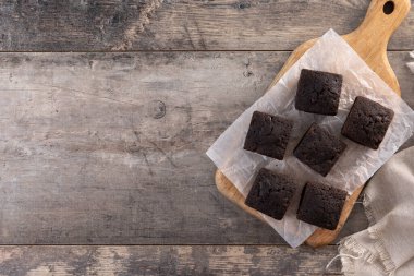 Ev yapımı çikolatalı brownie ve tahta masanın üzerinde şeker tozu. Üst Manzara. Boşluğu kopyala
