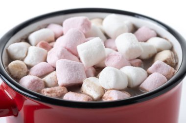 Beyaz arka planda izole edilmiş kırmızı bardakta kremalı sıcak çikolata içeceği. Kapat.