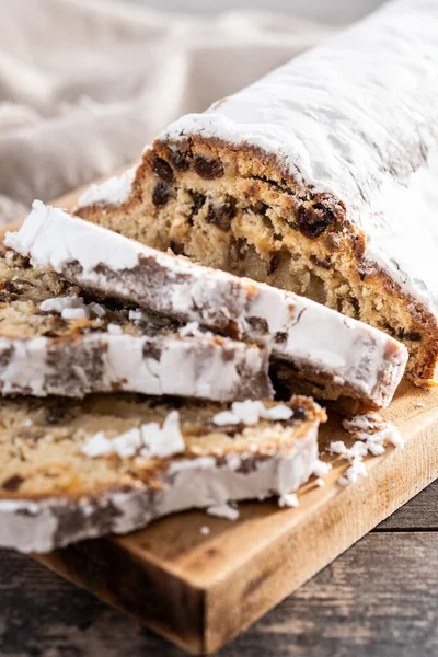 Geleneksel Noel Stollen üzümlü ve pudra şekerli ahşap masada. Kapat.