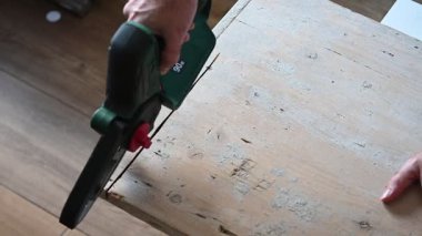 Kablosuz testere tahta kesiyor. Evde DIY kavramı