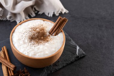 Tahta kasede sütlaç, siyah tahta arka planda. Boşluğu kopyala