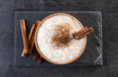 Tahta kasede sütlaç, siyah tahta zemin üzerinde.