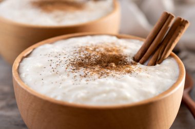 Tahta masadaki tahtadan kasede tarçınlı sütlaç. Kapat.