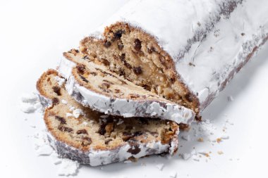 Geleneksel Noel Stollen, beyaz arka planda izole edilmiş kuru üzüm ve pudra şekerli. Kapat.