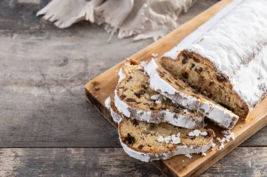 Geleneksel Noel Stollen, kuru üzüm ve pudra şekeriyle ahşap masada. Boşluğu kopyala